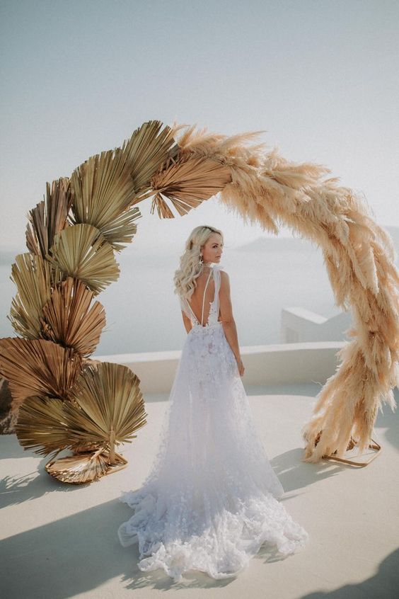 a trendy circle wedding arch done with dried fronds and pampas grass looks heavenly