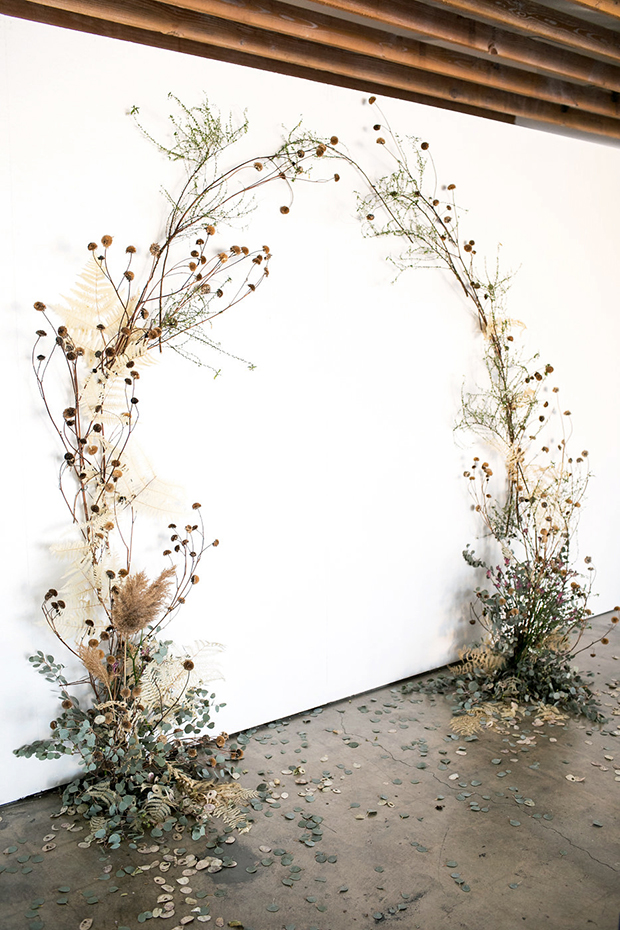 a fantastic wedding ceremony arch of eucalyptus, dried leaves and herbs plus dried billy balls looks ethereal and delicate