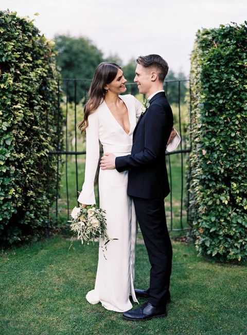 a modern plain wedding dress with bell sleeves and a plunging neckline