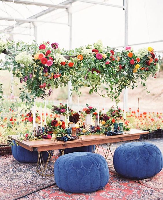 a super lush greenery and bright bloom decoration over the reception table for a bright boho wedding