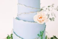 26 a pastel blue wedding cake with a raw gilded edge and a blush bloom for decor