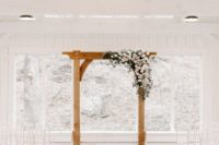 26 a pure white wedding ceremony space with white chairs and a wooden frame decorated with blush and white blooms