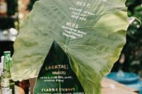 29 a bar wedding menu done on two large leaves is a very creative idea for a tropical wedding