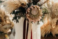 33 a statement neutral boho wedding bouquet with pampas grass, feathers, loutes and a king protea