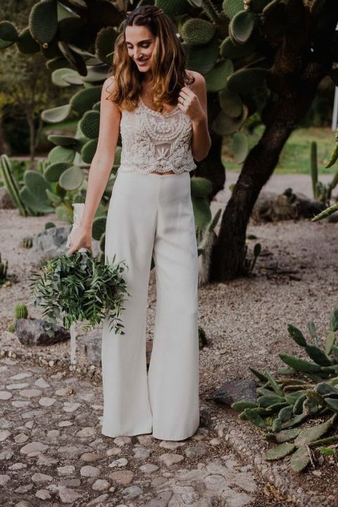 a bridal pantsuit with a lace strap crop top and wide leg pants is a trendy boho idea