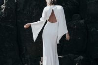 43 a minimalist wedding dress with bell sleeves and a triangle cutout back