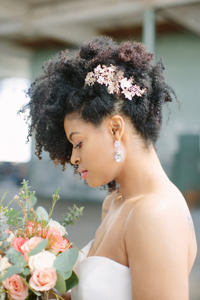 natural curls swiped up and accented with a gold botanical hairpiece to make it look more chic