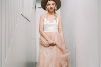 02 The bride was wearing a spaghetti strap wedding dress with a layered pink skirt and a wide brim hat