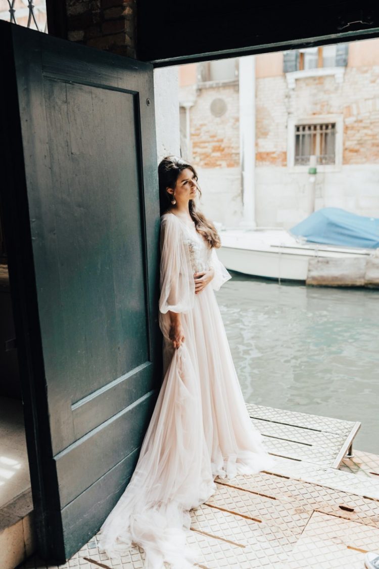 The first wedding dress was a blush one, with flowy sleeves and an embellished bodice plus a train