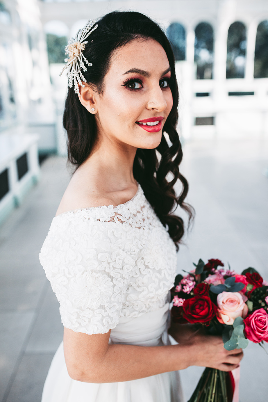 The wedding makeup was done with long lashes, with a bright lipstick and pink shadows