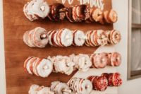 03 a mini glazed donut wall with white calligraphy is a cool idea to complete your dessert table
