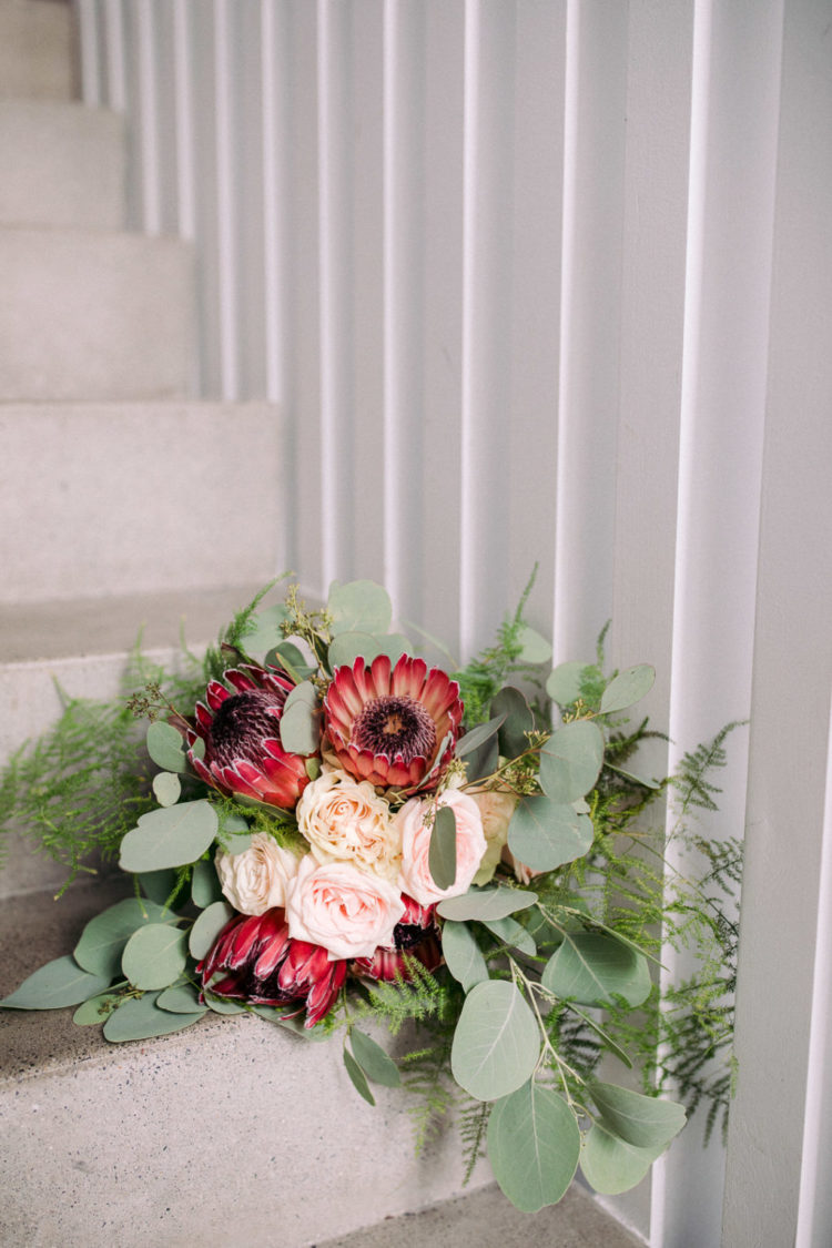 The wedding bouquet was done with blush roses, proteas and greenery