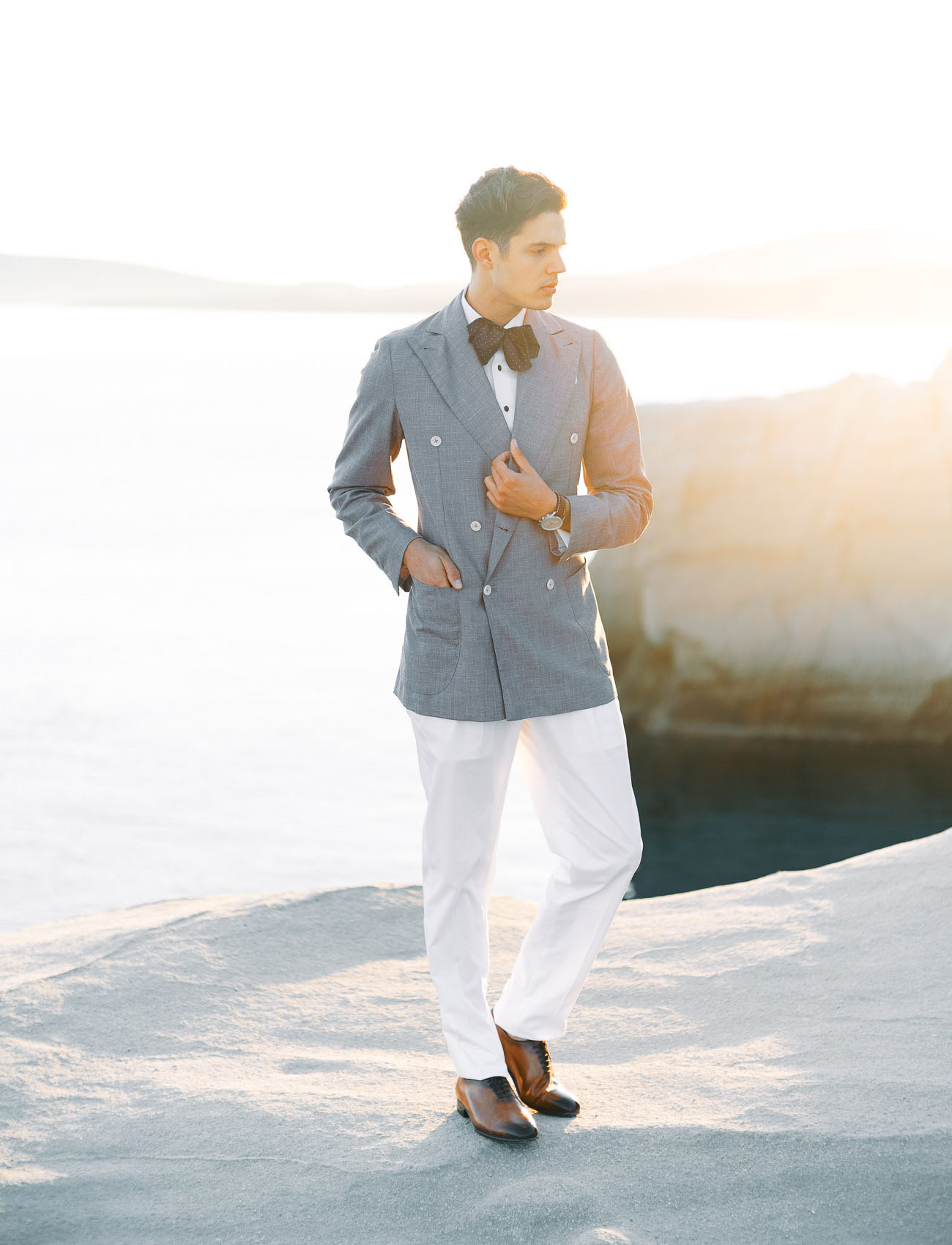 The groom was wearing an island look with white pants, vintage shoes, a grey oversized blazer and a polka dot bow