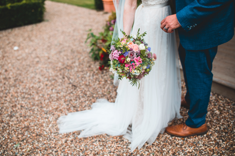 The wedding bouquet was shaped as a ball and was done with purple, pink, red and white blooms and greenery
