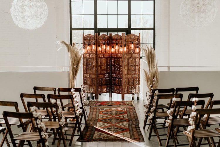 The wedding ceremony space was done with a carved wooden screen as a backdrop, rugs and some pampas grass