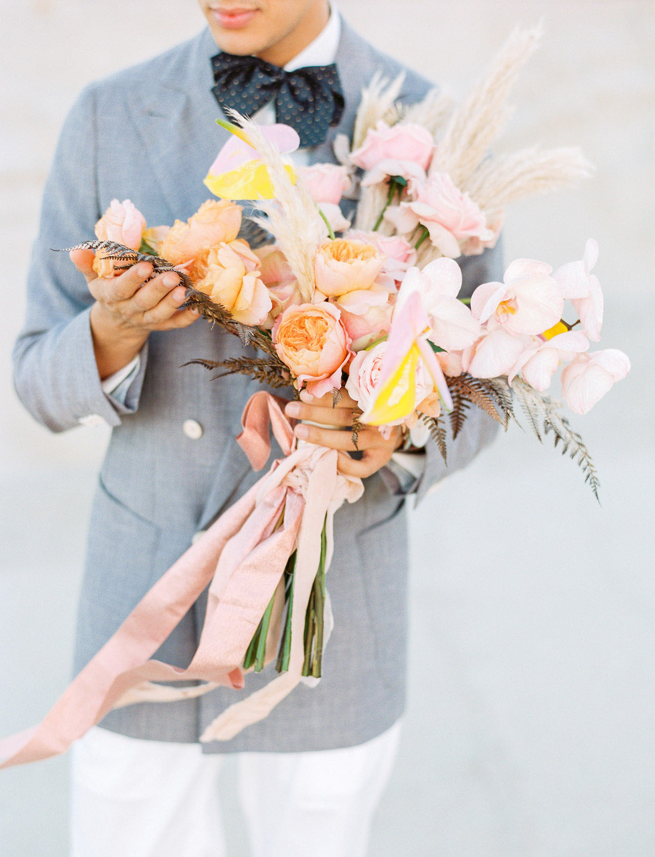 The wedding bouquet was romantic and pastel, with blush and peahcy blooms and pampas grass