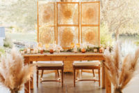 08 The sweetheart table was styled with pampas grass, woven screens, greenery table runners and candles