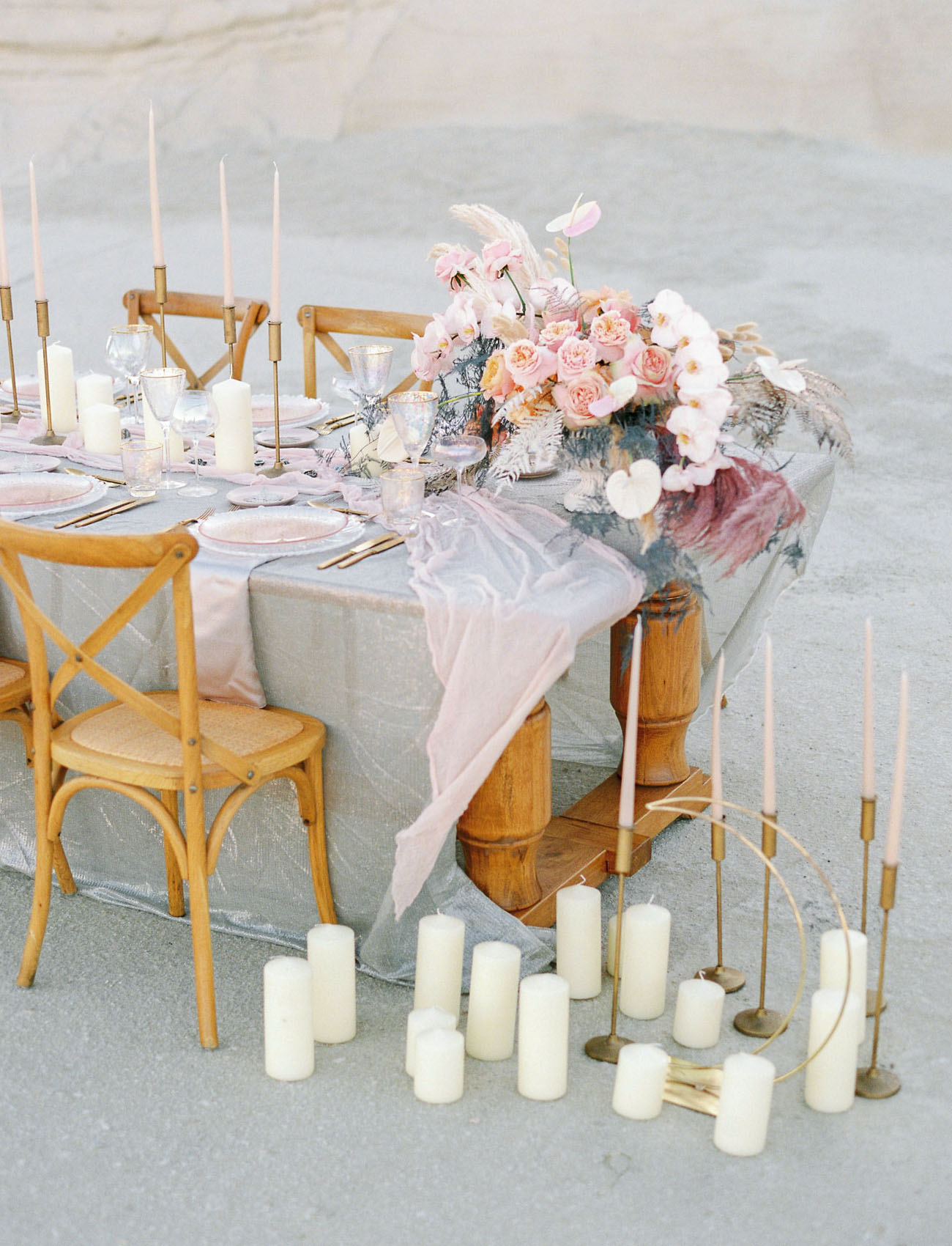 The table was decorated with delicate linens, pastel florals, candles and pink glass chargers
