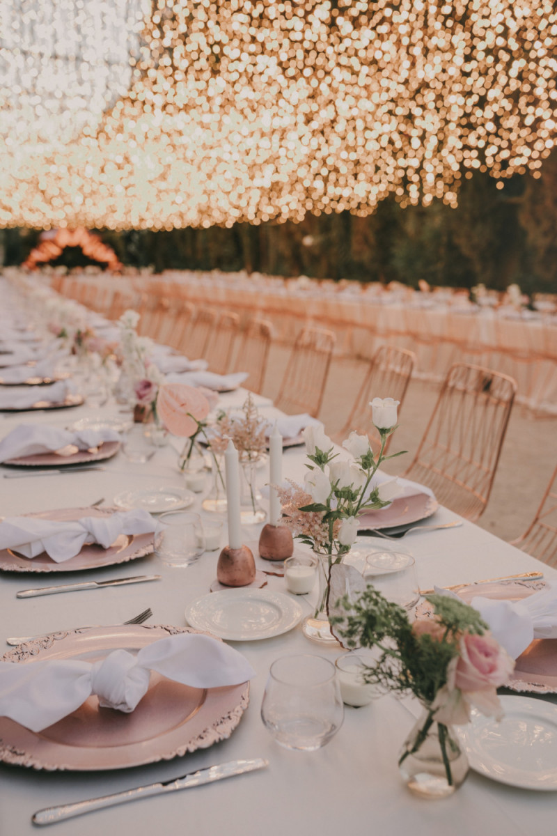 The tables were decorated with pink chargers, copper candle holders, white and pink flowers and white napkins