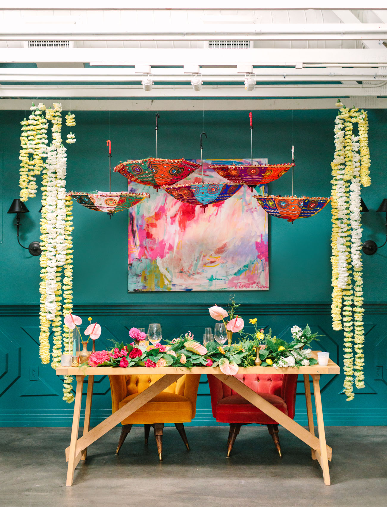 The sweetheart table featured greenery and bold blooms, colorful umbrellas and an artwork