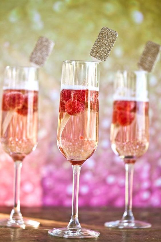 signature drinks with raspberies and wooden drink stirrers with gold glitter tops are amazing