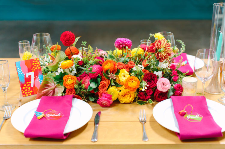 Bodl florals and greeneyr, bright napkins and cards were present on each table