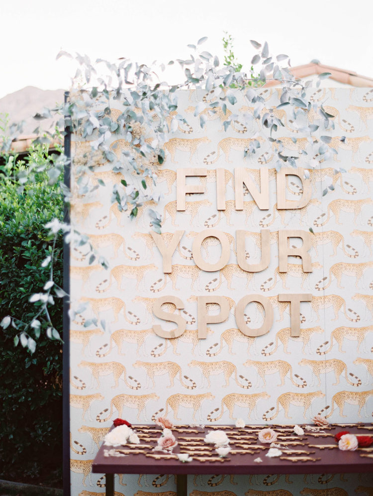 a seating chart done with a real leopard print and plywood letters is a cool idea that looks bold and fun