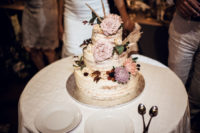 13 The naked wedding cake was decorated with pastel blooms, berries and greenery