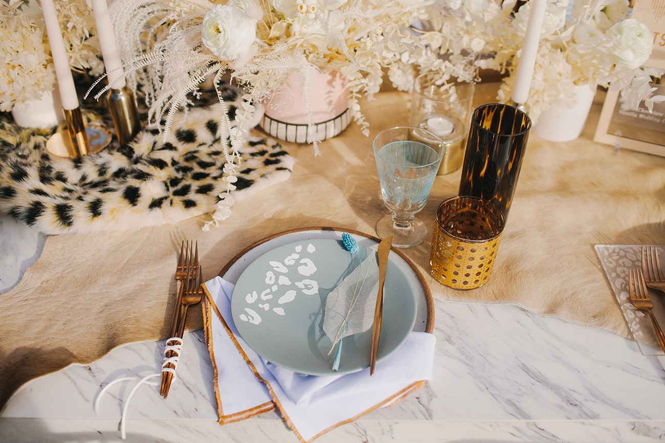 a unique wedding tablescape with a leopard print runner and plate is a chic and stylish idea