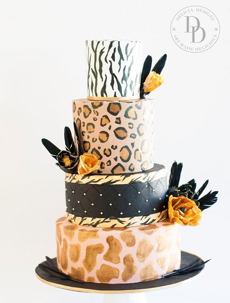 A bright and fun leopard and zebra print wedding cake in various colors, with blooms and feathers