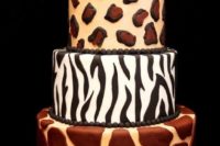22 a refined wedding cake with a number of animal prints and a black glitter tier on top is wow