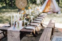 a boho tablescape with macrame, candles and bright blooms, benches and a teepee for a micro wedding