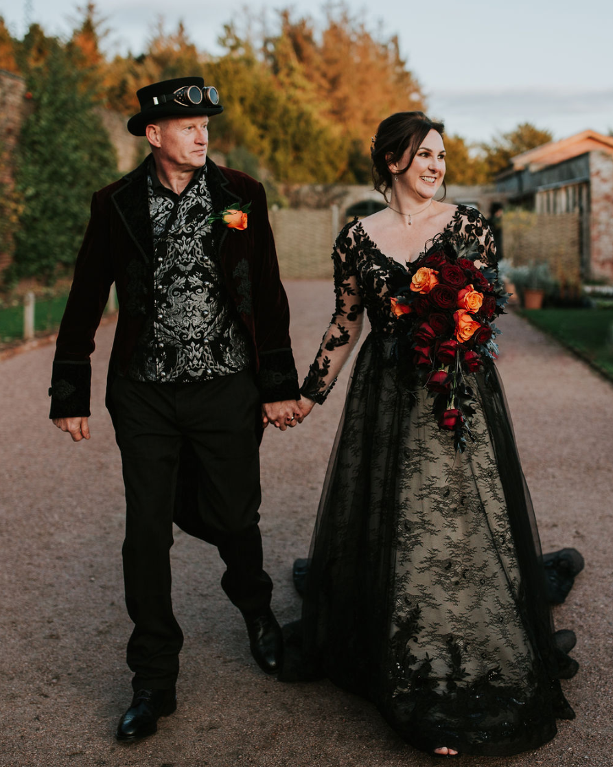 The bride was wearing a black lace V neckline wedding dress with long sleeves, the groom was wearing a black suit and a whimsy shirt