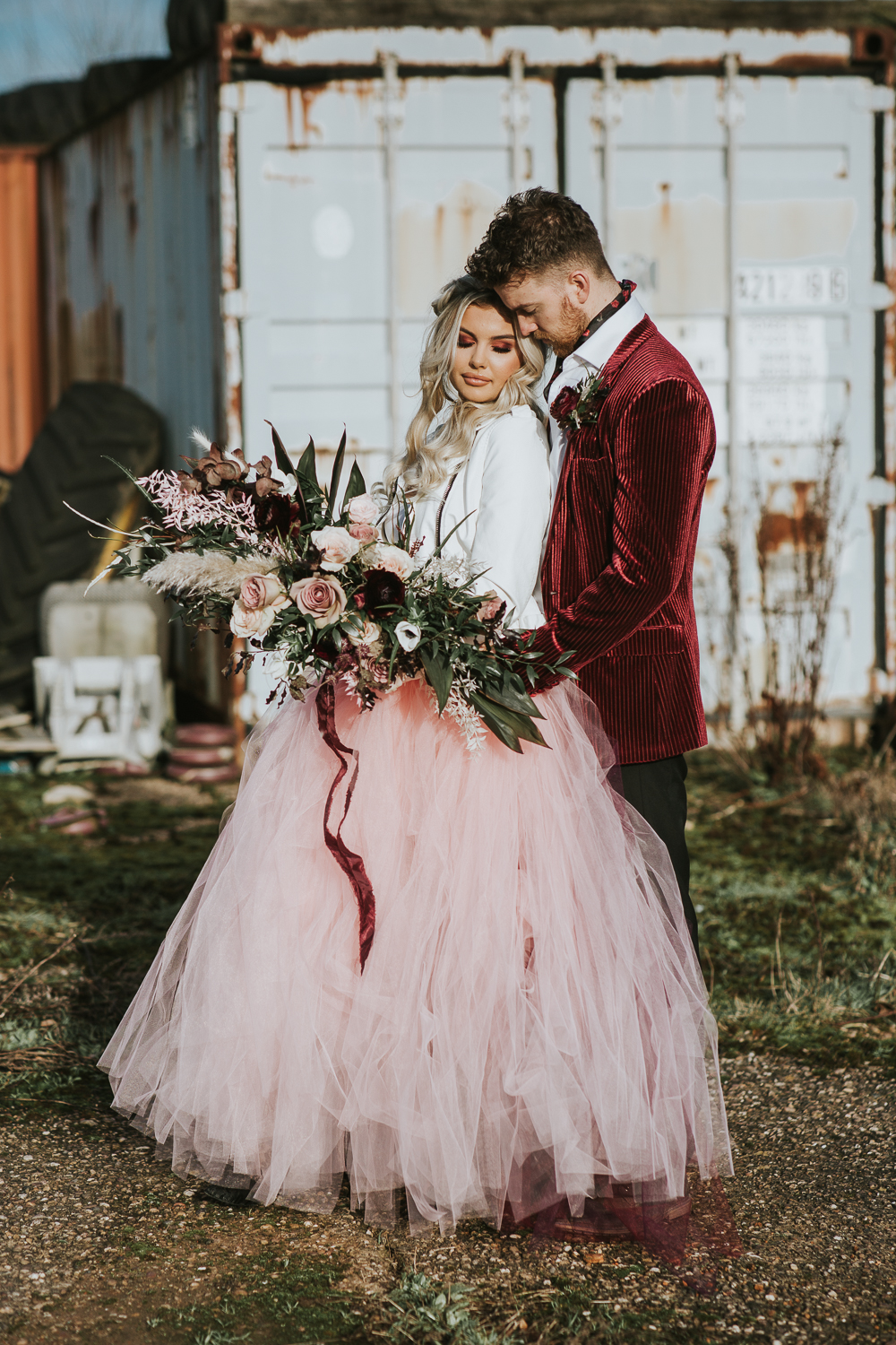 The bride was wearing a pink tutu, a white leather jacket and a half updo with waves