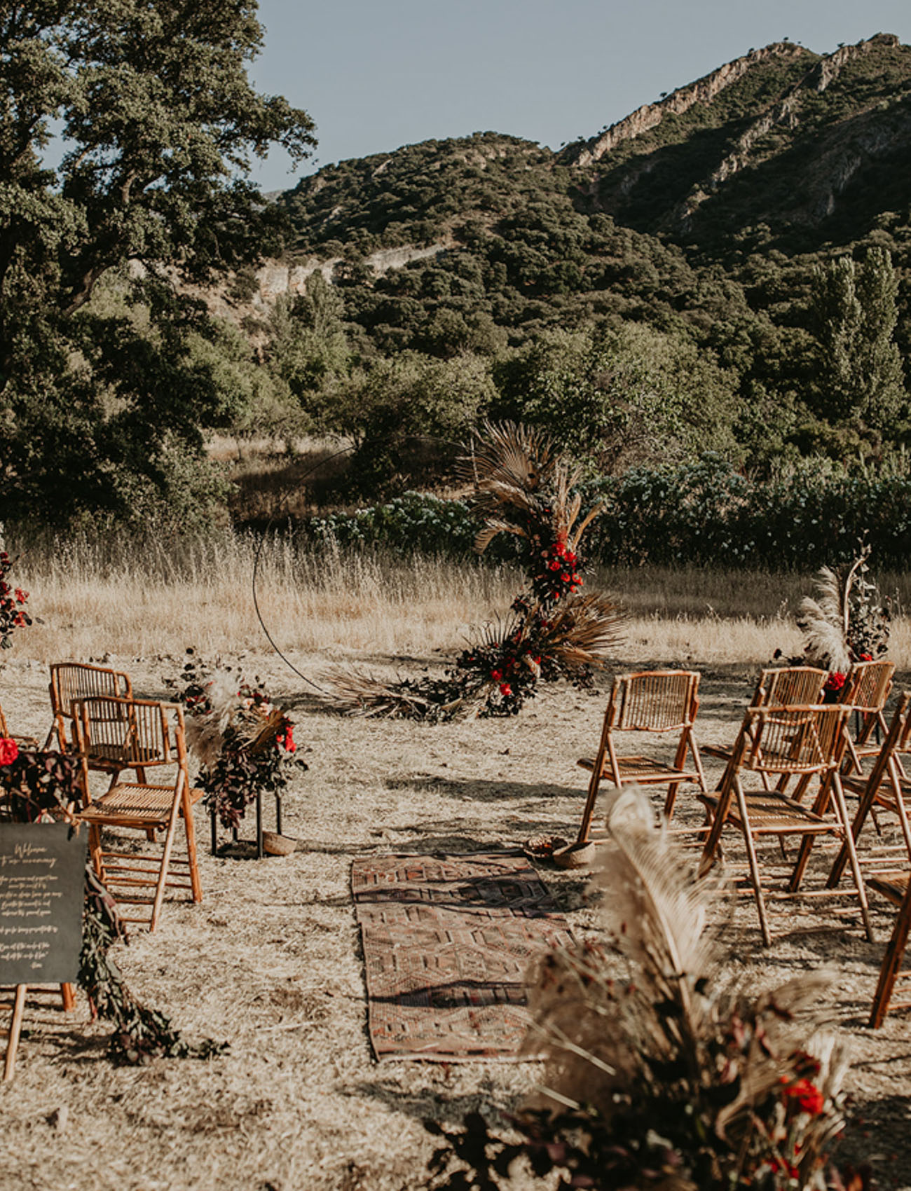 The wedding ceremony space was done with bright blooms, greenery, pampas grass and dried fronds