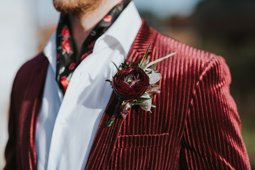The groom wore a burgundy velvet blazer, a white shirt and a floral neck tie