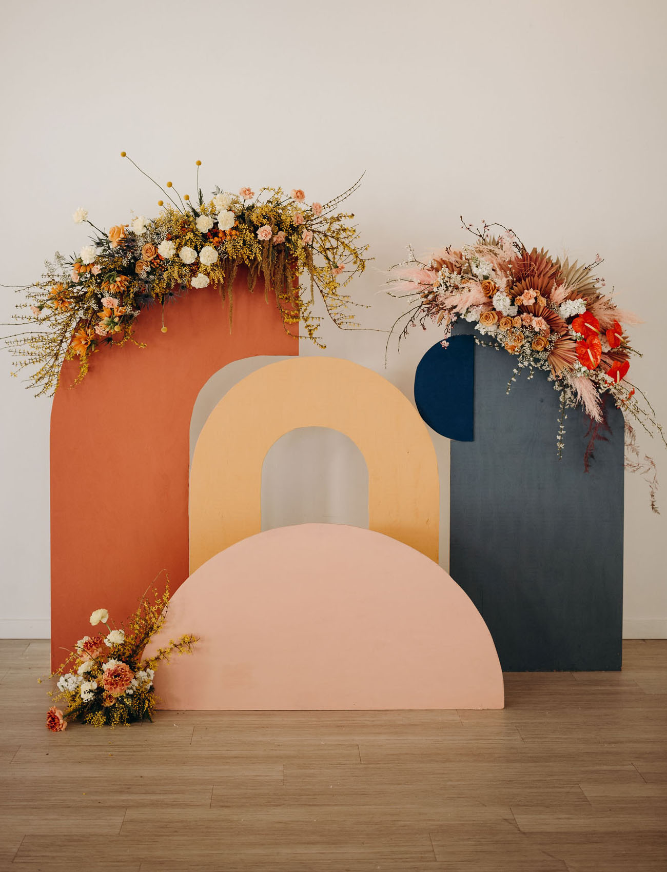 The wedding backdrop was a muted one, a cutout wooden backdrop with bright blooms and greenery