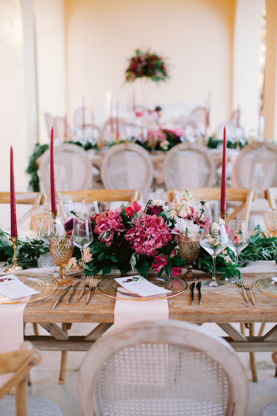 The table was styled with an airy runner, bright blooms and greenery, colorful candles and gold touches
