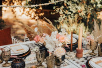 07 The wedding table was a woven one, with fringe chargers, peachy napkins, amber candles and black vases