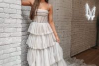 07 an off white modern romantic wedding dress with a corset-like bodice on spaghetti straps and tiered tulle skirt