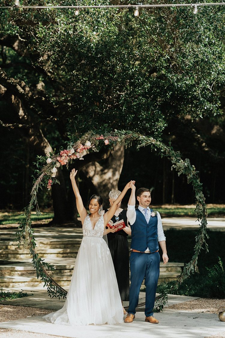 The wedding arch was done with greenery, pink and blush blooms