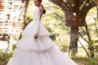 09 a modern wedding ballgown with a plain long sleeve bodice with an illusion back and a tiered tulle skirt with a train