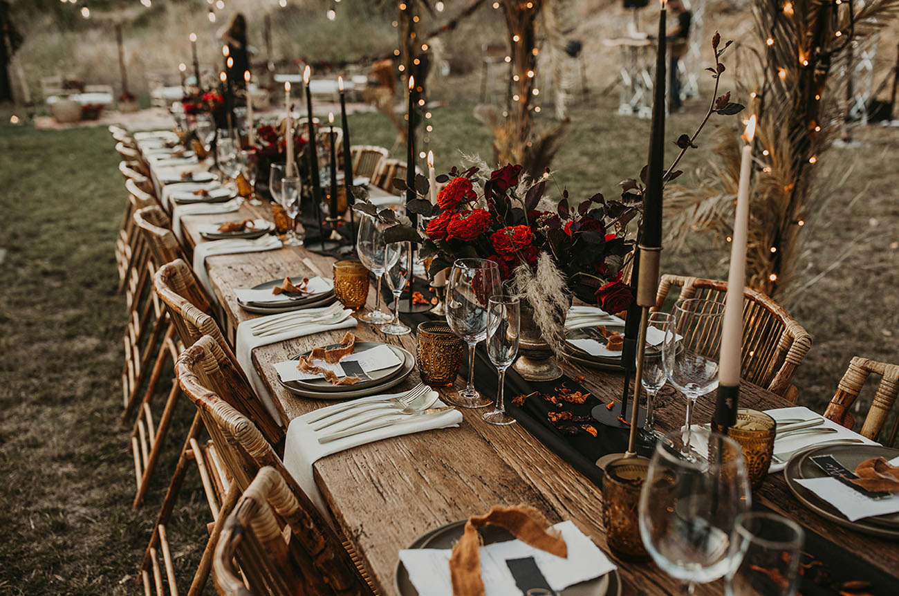 The wedding table was set with bright blooms, black candles, dried elements