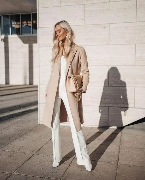 a chic neutral outfit with a white top and pants plus booties and a nude coat and a bag