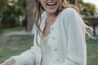 a neutral cardigan paired with a slip wedding dress and layered necklaces create a lovely modern and casual look