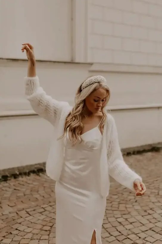 A romantic and cute look with a plain spaghetti strap wedding dress, a semi sheer cardigan on top and a headband
