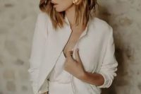 a simple and minimalist plain cropped bridal jacket with a zip and cropped sleeves is a chic addition to the look