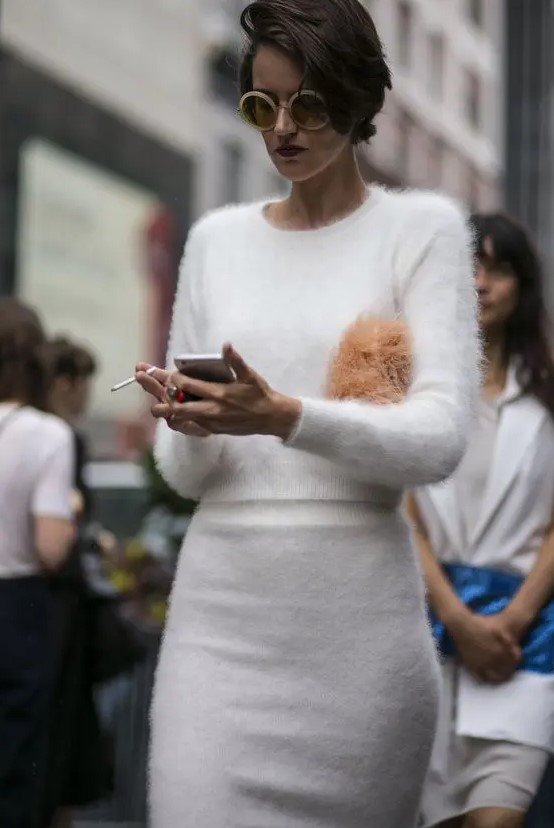 a simple and stylish modern bridal shower look with a fine knit white angora sweater with a scoop neck and a skirt, a fluffy bag is a cool solution for a modern bride-to-be