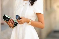 a textured ivory skater dress with short sleeves and layered necklaces is a classy idea for a spring or summer bridal shower