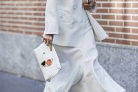 a white maxi dress, a white jacket, white boots and a clutch for an elegant winter bridal shower look